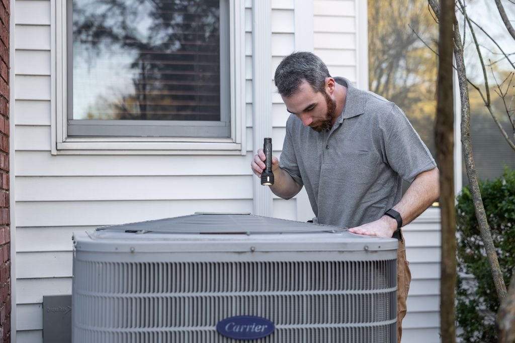 HVAC technician inspecting an outdoor residential unit — FieldEdge review