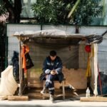 Construction worker using a phone while seated at a city work site — redirect the call with the script and book the diagnostic