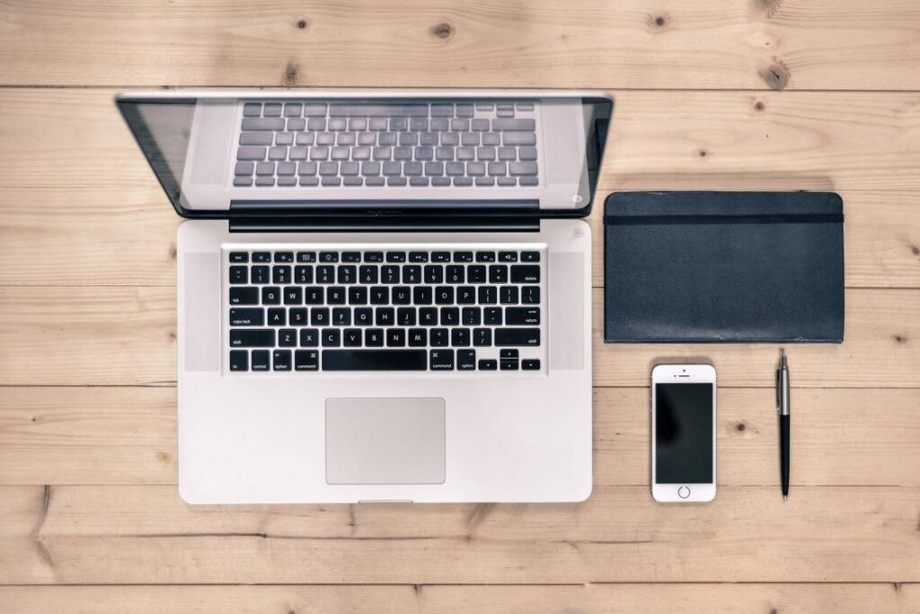 Laptop, smartphone, and notebook on a desk
