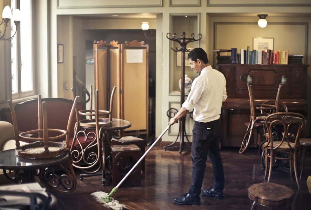 Cleaner mopping a cafe floor — recurring cleaning work like this is what the BookingKoala vs ZenMaid comparison is about