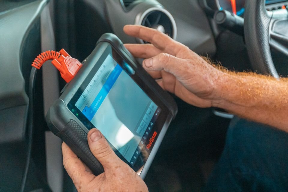 Technician's hands using a tablet inside a work vehicle