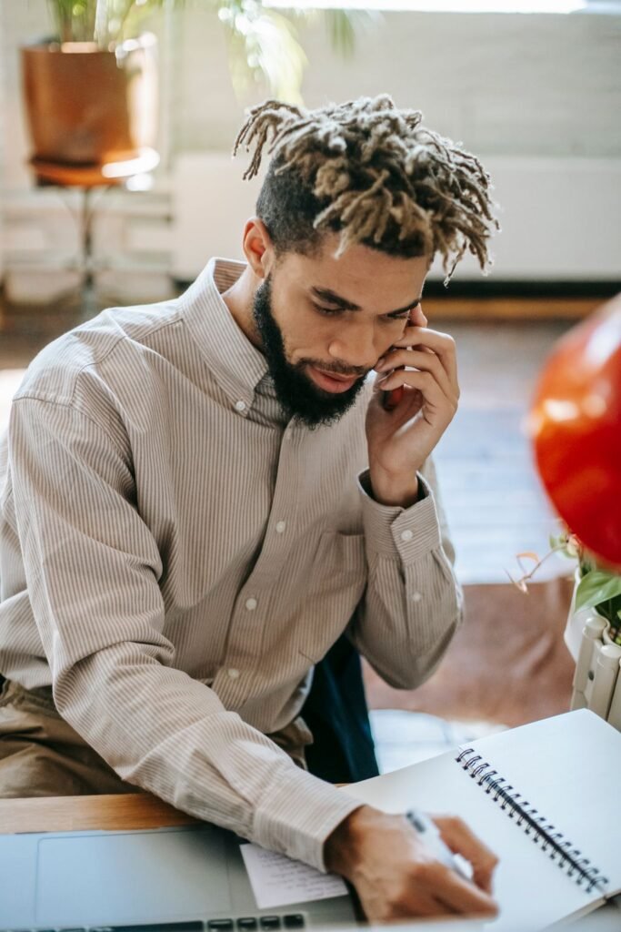 Business owner taking notes during a phone call, as part of a weekly review after an AI receptionist stopped working