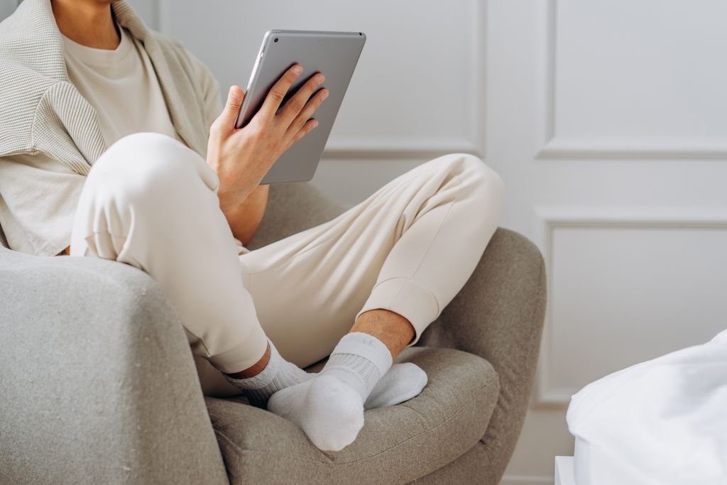 Person holding a tablet while sitting at home