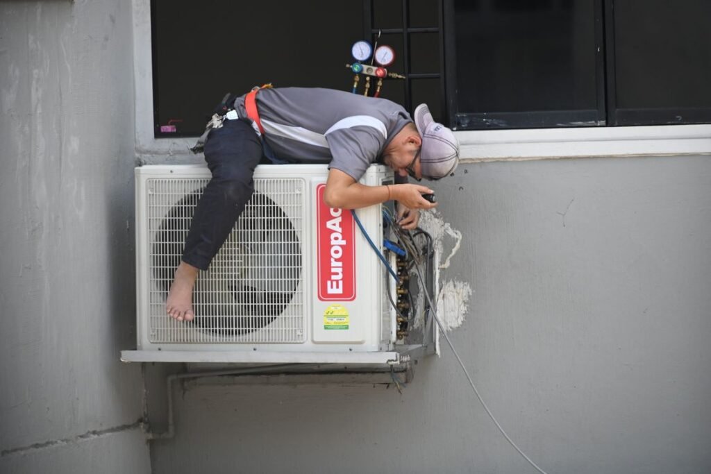 Technician repairing an outdoor air conditioning unit