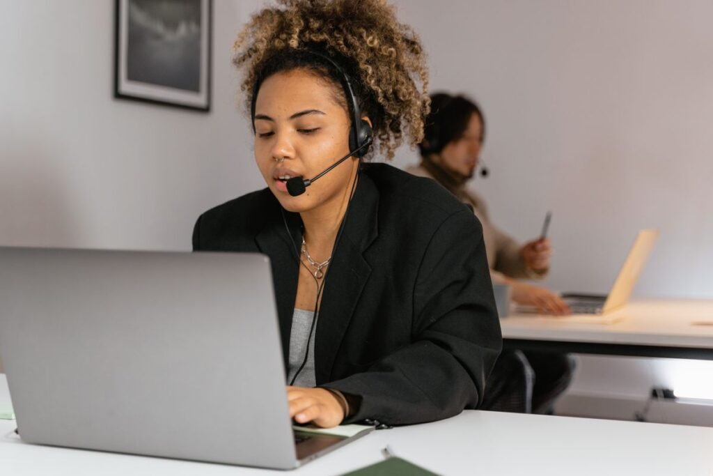 Customer service agent with a headset working at a laptop