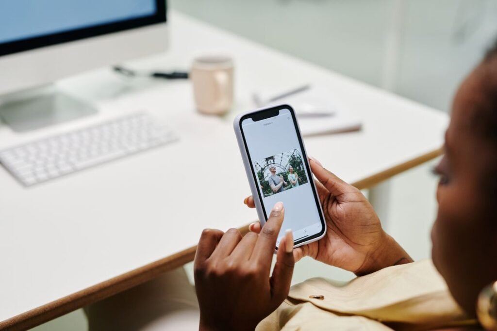 Hands holding a smartphone at a desk